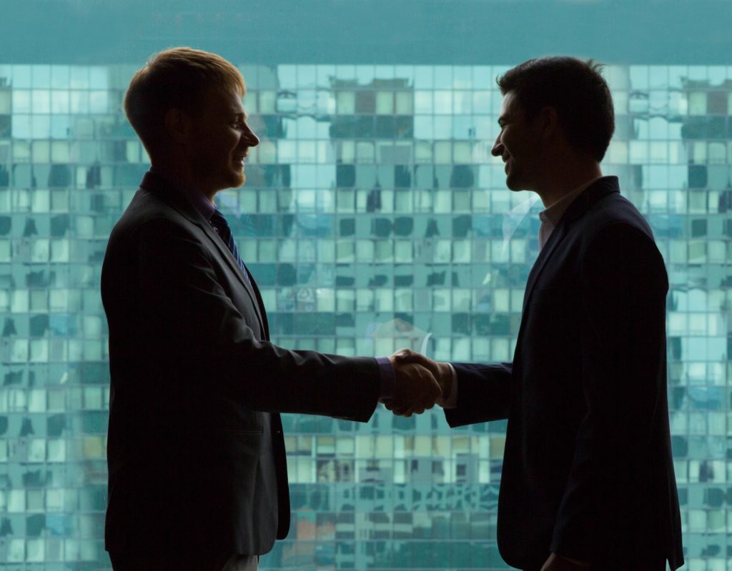 business-people-shaking-hands-with-green-background-office-buildings business-people-shaking-hands-with-green-background-office-buildings