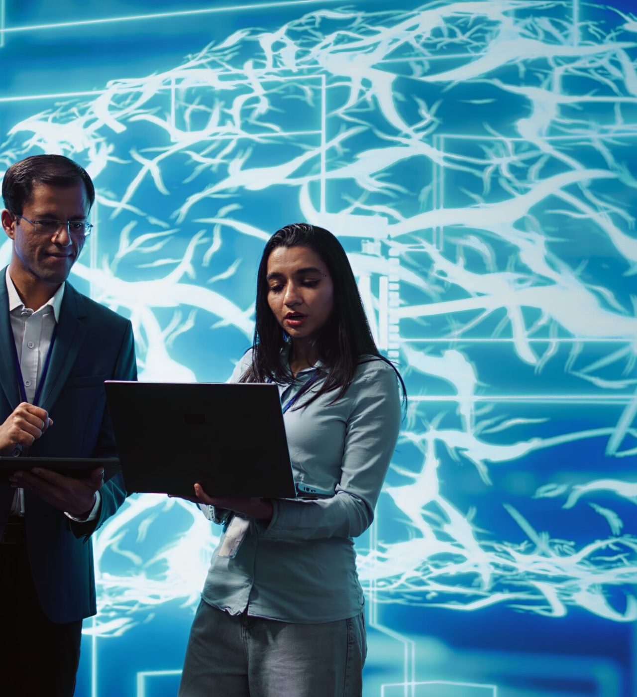 Teamworking colleagues using AI neural networks modeled after human brain Teamworking colleagues using AI neural networks modeled after human brain to solve complex problems. Team of IT specialists using deep learning to look at data and complete tasks, camera B